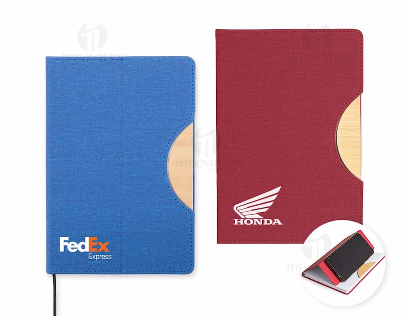 Caderneta com suporte de celular em uma mesa de escritório com notebook, papel em branco, cartão vazio, notas amarelas, livro, textos, padrões e texturas coloridas.