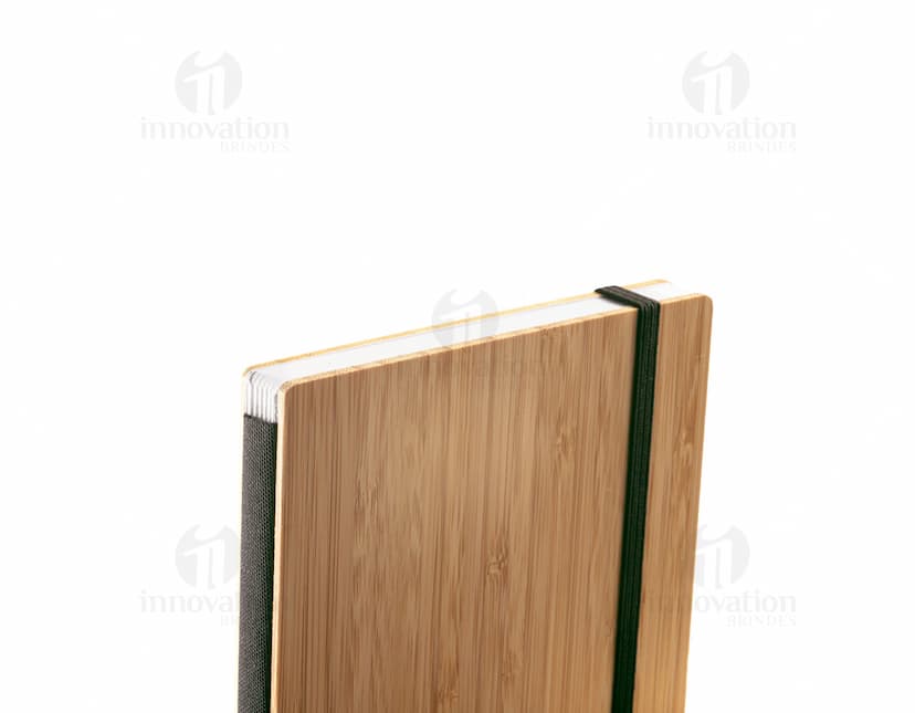 Caderno de bolso preto com capa de couro e elástico de fechamento.