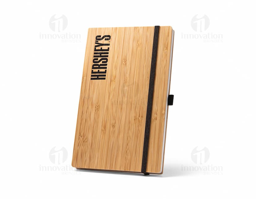 Caderno de bolso preto com capa de couro e elástico de fechamento.