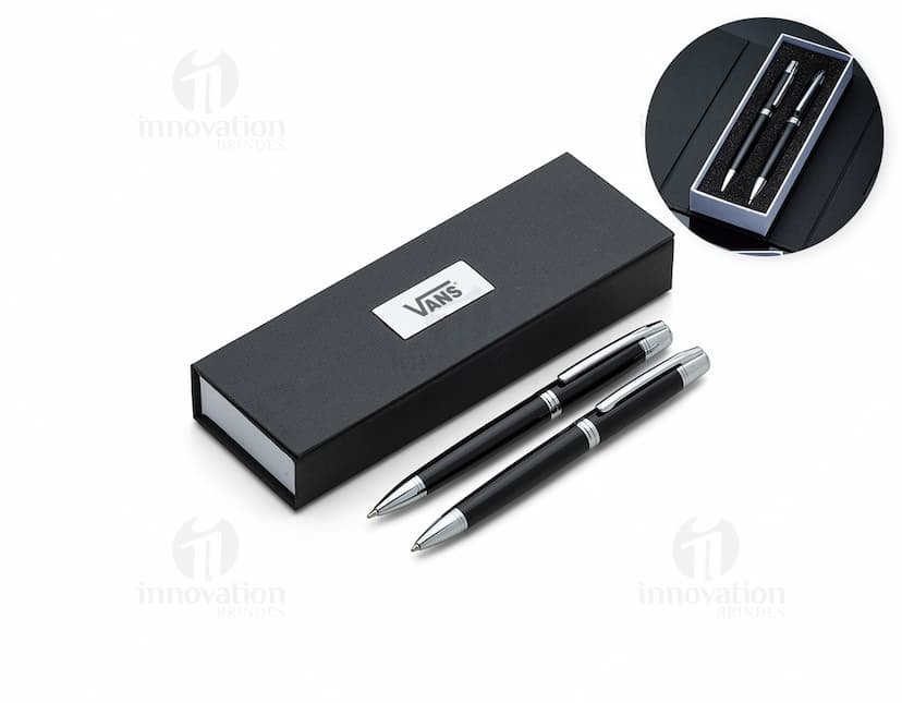 Conjunto de caneta e lapiseira de metal em fundo branco. A caneta e a lapiseira possuem detalhes cromados e são apresentadas em uma caixa elegante.