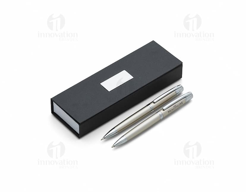 Conjunto de caneta e lapiseira de metal em fundo branco. A caneta e a lapiseira possuem detalhes cromados e são apresentadas em uma caixa elegante.
