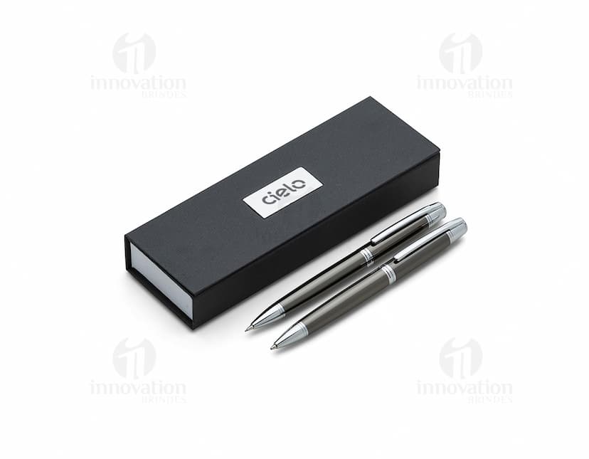 Conjunto de caneta e lapiseira de metal em fundo branco. A caneta e a lapiseira possuem detalhes cromados e são apresentadas em uma caixa elegante.