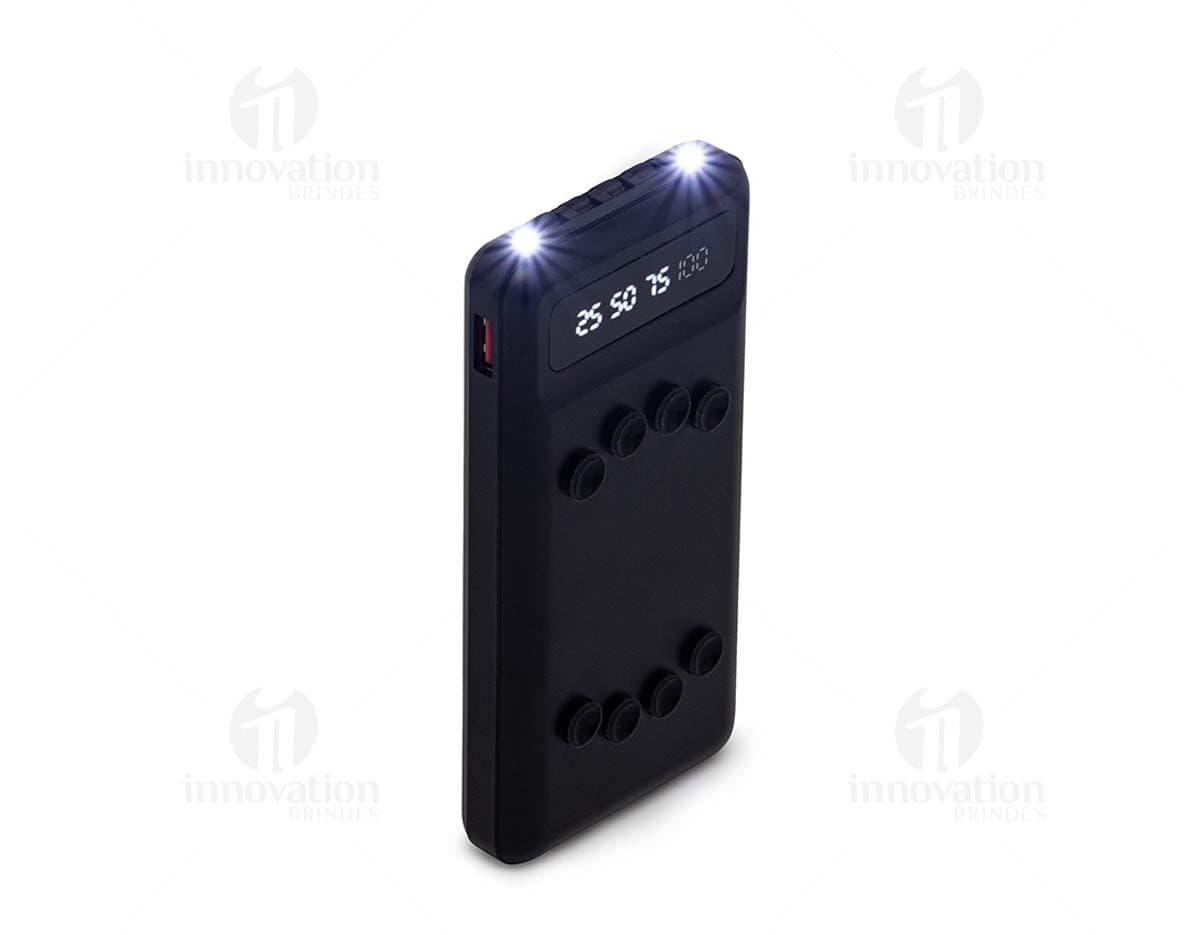 Power Bank preto com conexões USB, pronto para carregar dispositivos eletrônicos. Aparece em um fundo branco.