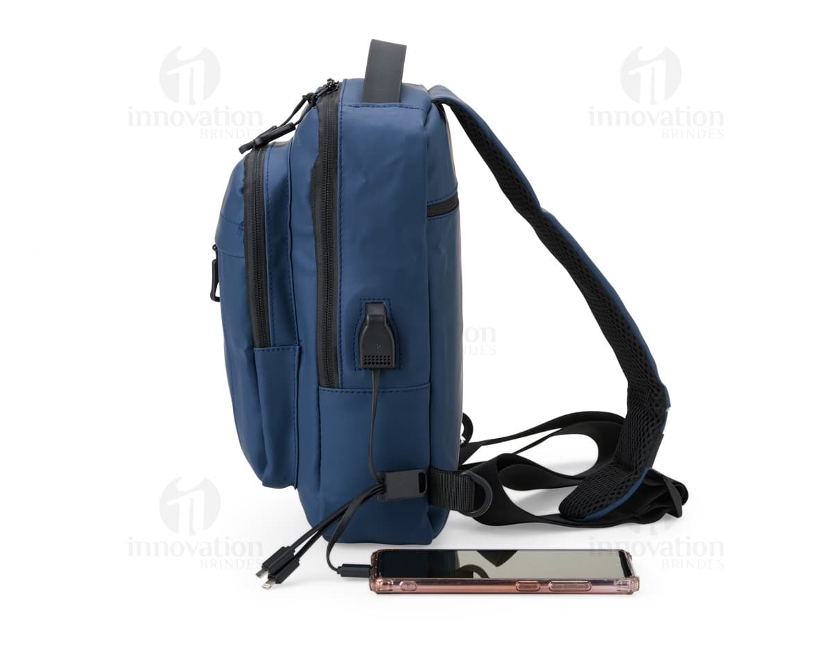 Mochila de ombro com bolsos, zíperes e entrada USB para carregamento de dispositivos eletrônicos. Cor preta e material resistente. Ideal para uso diário e viagens.