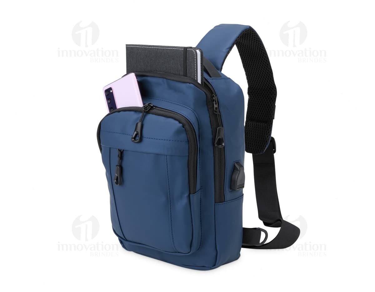 Mochila de ombro com bolsos, zíperes e entrada USB para carregamento de dispositivos eletrônicos. Cor preta e material resistente. Ideal para uso diário e viagens.