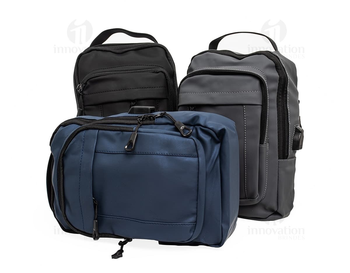 Mochila de ombro com bolsos, zíperes e entrada USB para carregamento de dispositivos eletrônicos. Cor preta e material resistente. Ideal para uso diário e viagens.