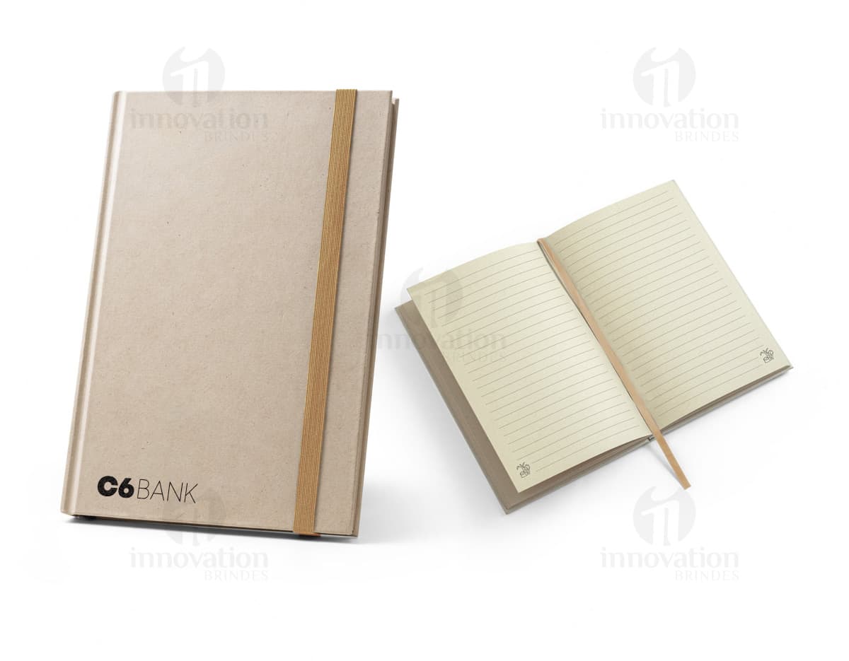 Caderno EcoCana com capa de papel reciclado e elástico azul. Interior com folhas de papel ecológico sem pauta, ideal para anotações e desenhos. Tamanho A5.