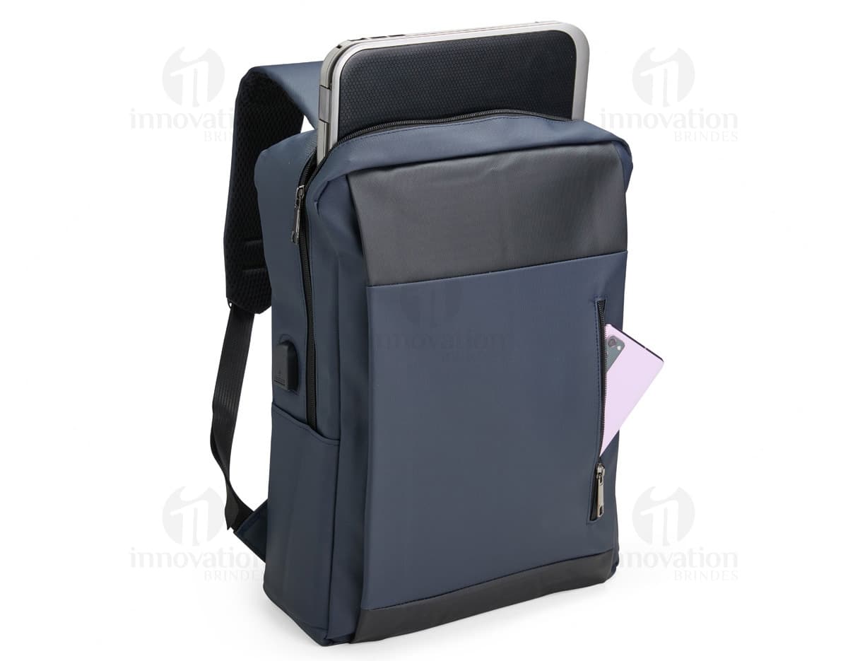 Mochila feita de material sintético PU em cor marrom, com detalhes de costura e bolsos frontais. Alças ajustáveis e fecho de zíper na parte principal.