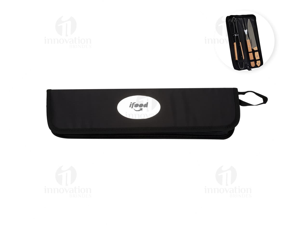 Kit churrasco composto por 3 peças: faca, garfo e pegador de carne em aço inoxidável, sobre fundo de madeira.