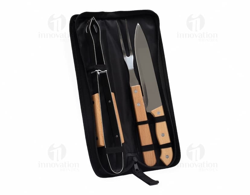 Kit churrasco composto por 3 peças: faca, garfo e pegador de carne em aço inoxidável, sobre fundo de madeira.