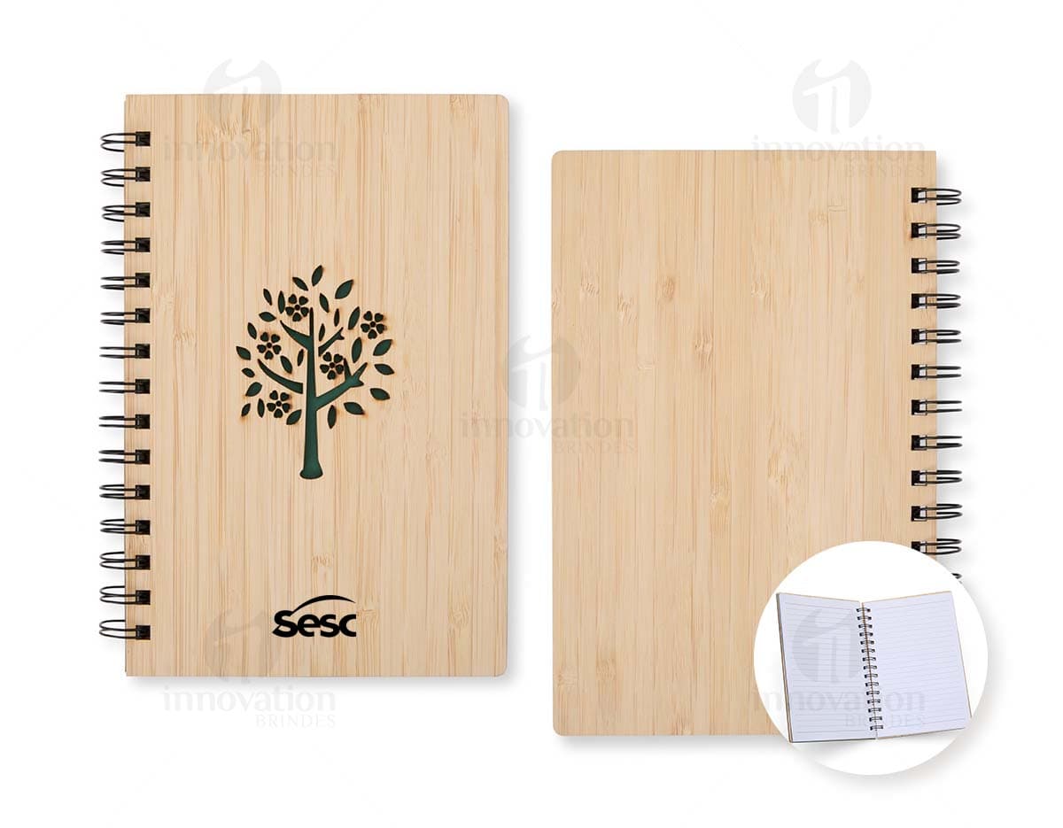 Caderno Bambu com capa de tecido estampado em tons de verde e marrom, folhas em papel reciclado e marcador de páginas de fita verde.