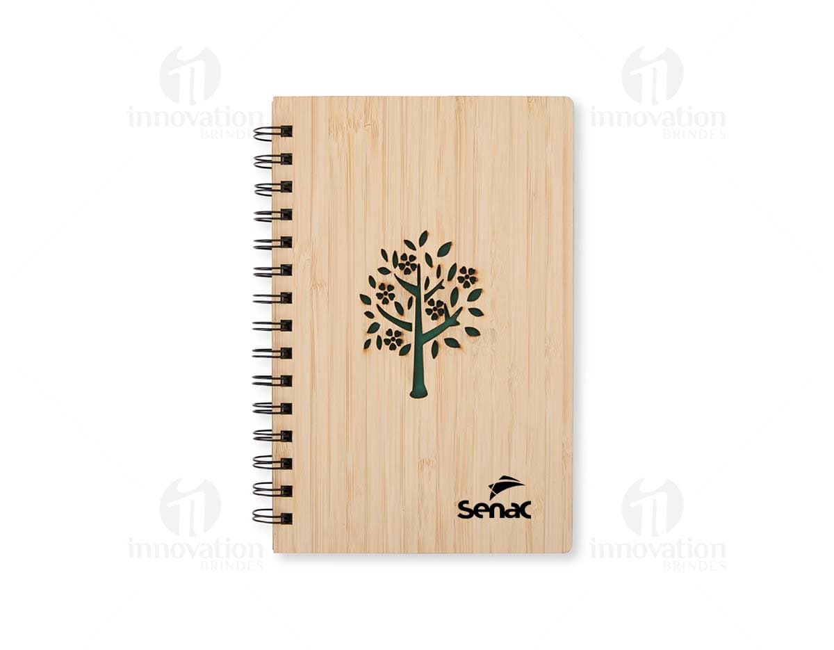 Caderno Bambu com capa de tecido estampado em tons de verde e marrom, folhas em papel reciclado e marcador de páginas de fita verde.
