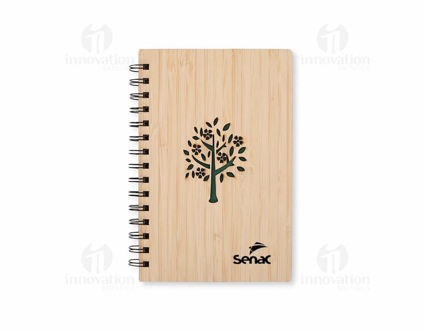 Caderno Bambu com capa de tecido estampado em tons de verde e marrom, folhas em papel reciclado e marcador de páginas de fita verde.