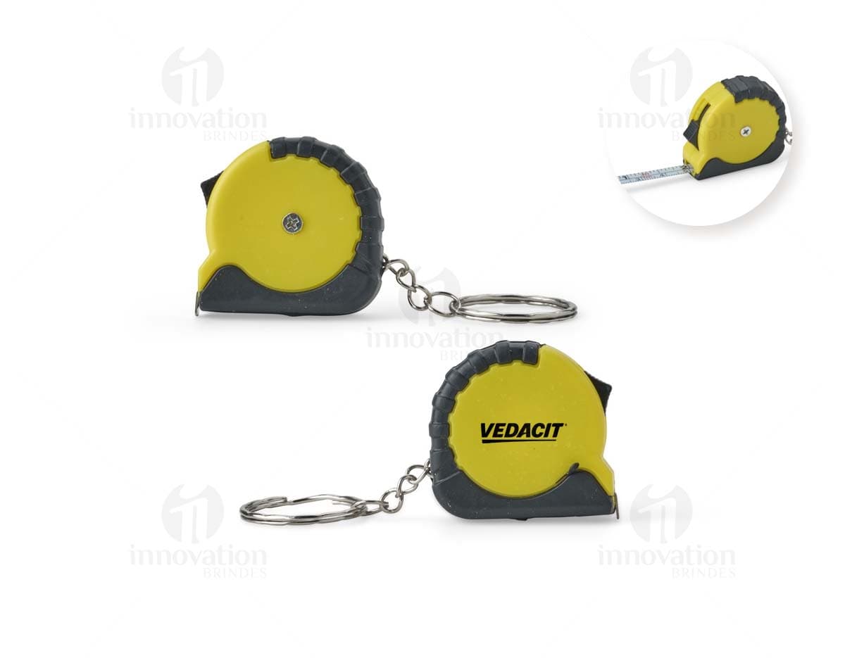 Chaveiro Trena Plástico 1 Metro: Chaveiro em forma de trena de plástico com um metro de comprimento.