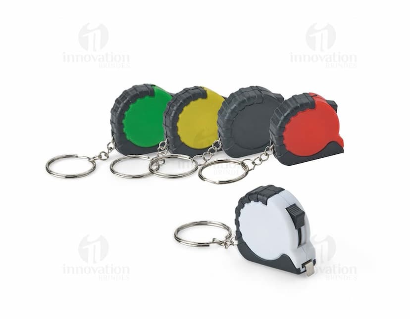 Chaveiro Trena Plástico 1 Metro: Chaveiro em forma de trena de plástico com um metro de comprimento.