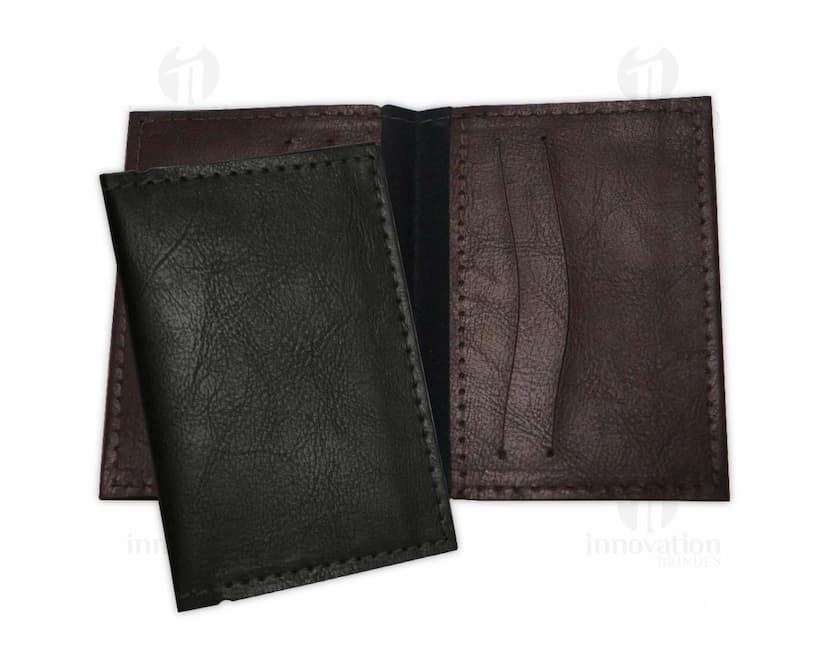 Porta cartão em couro sintético preto, com divisórias internas e fecho de botão.