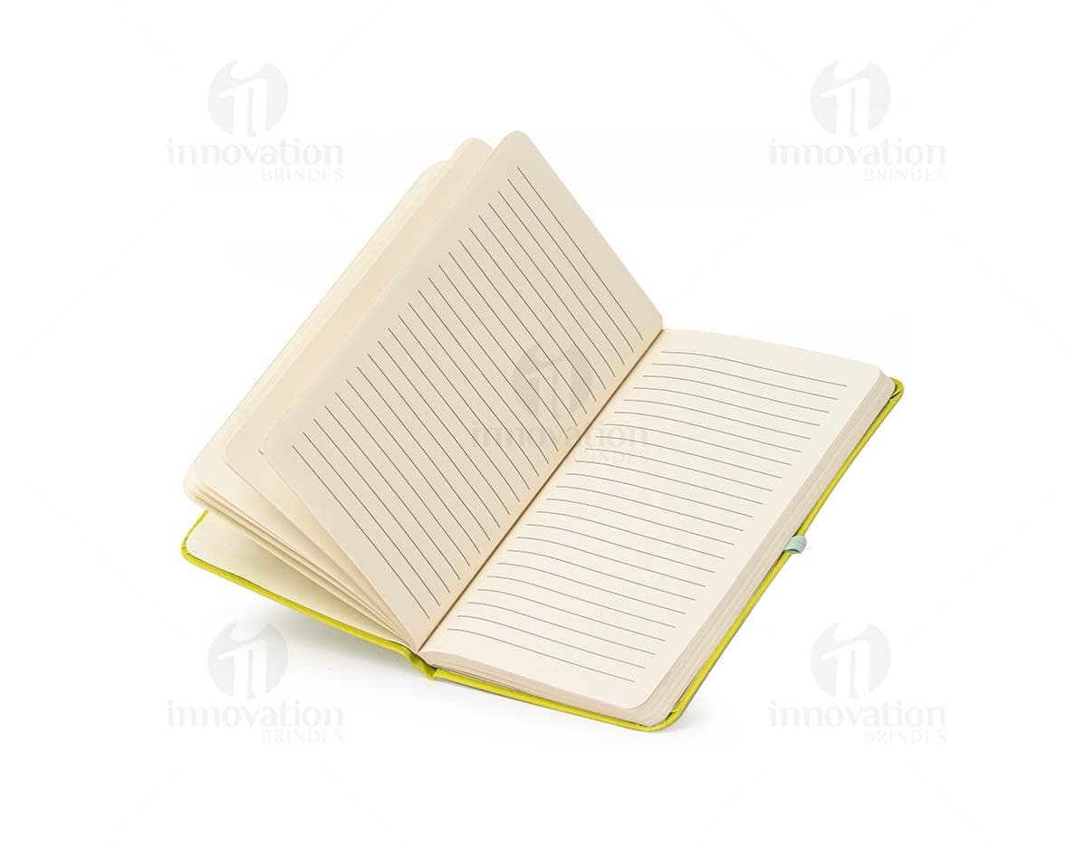 Caderneta de couro sintético vazia em um escritório amarelo, com espaço para inserir notas e documentos.