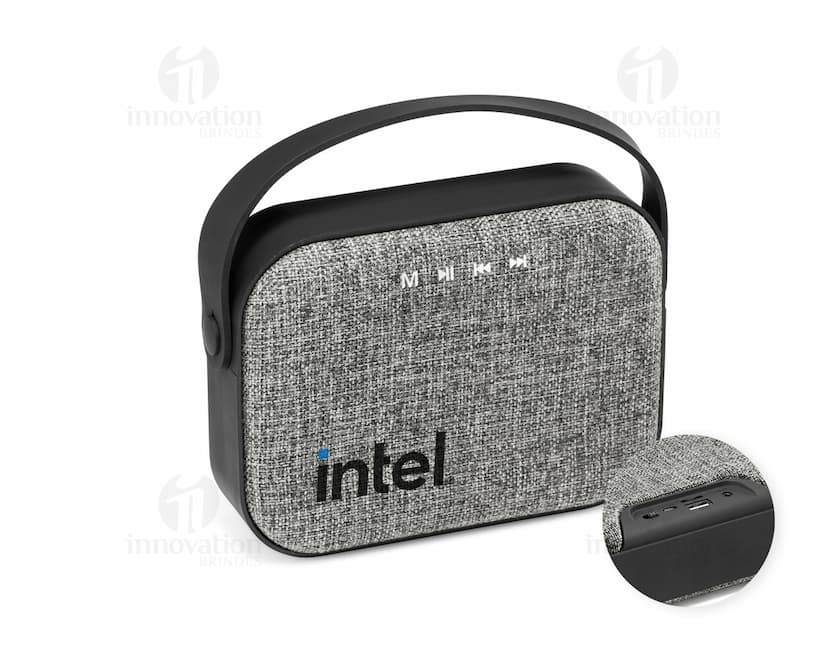 Caixa de som portátil TED em couro marrom e metal preto, elegante e moderna, com alça e zíper. Ideal para viagens e armazenamento de acessórios.