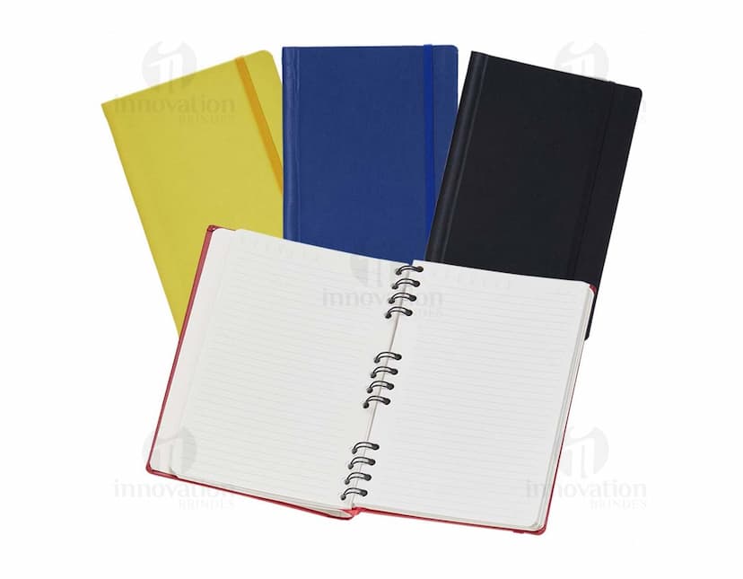 Caderneta Emborrachada com Wire-o em amarelo, design de quadro adesivo vazio em um notebook aberto, com papel em branco e um envelope de papel à direita, sobre fundo liso e limpo.