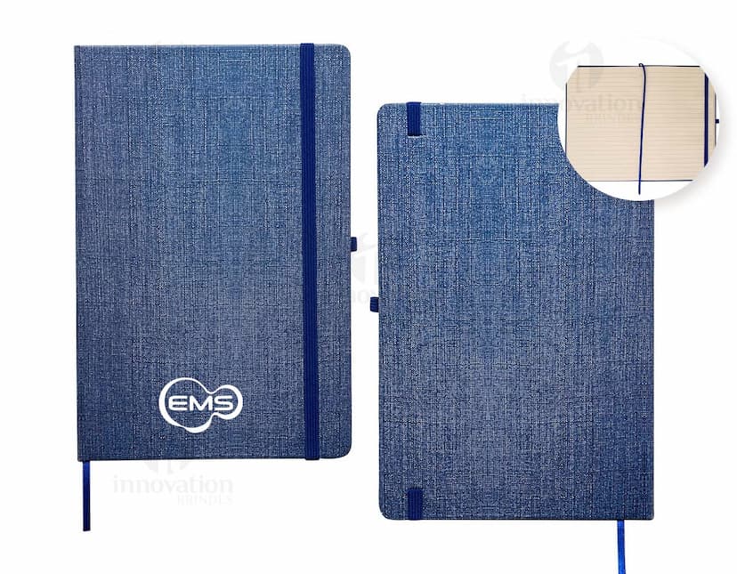 Caderneta A5 em papel texturizado antigo, com capa de tecido vintage em tom de marrom desgastado. O design é grunge e possui um padrão decorativo. O material é de fibra de algodão áspera, com uma superfície em canvas. Na capa, há um detalhe de costura em linha preta. O interior está em branco, com páginas vazias.