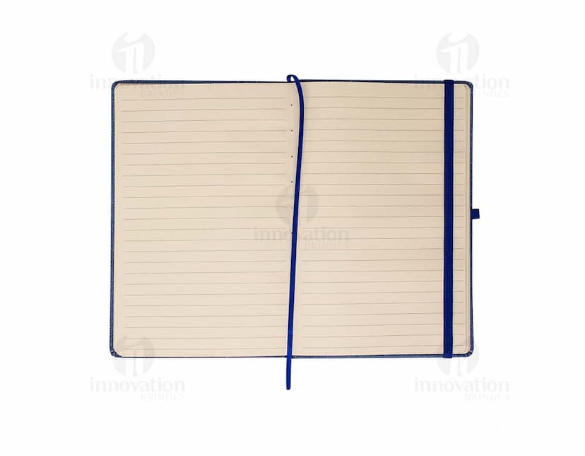 Caderneta A5 em papel texturizado antigo, com capa de tecido vintage em tom de marrom desgastado. O design é grunge e possui um padrão decorativo. O material é de fibra de algodão áspera, com uma superfície em canvas. Na capa, há um detalhe de costura em linha preta. O interior está em branco, com páginas vazias.