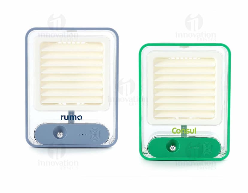 Climatizador portátil recarregável com design digital em 3D, equipamento de tecnologia elétrica que funciona como um aquecedor, com botões de metal e knob de controle. Ao lado, há um rádio e um notebook em um ambiente de escritório.