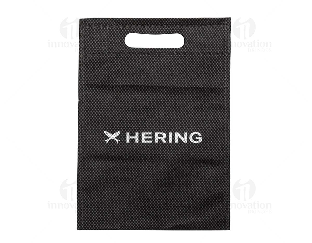 Carteira preta, bolsa de papelão vazia, notebook com quadro negro ao fundo, antigo cartão de memória em cima de um caderno de couro marrom.