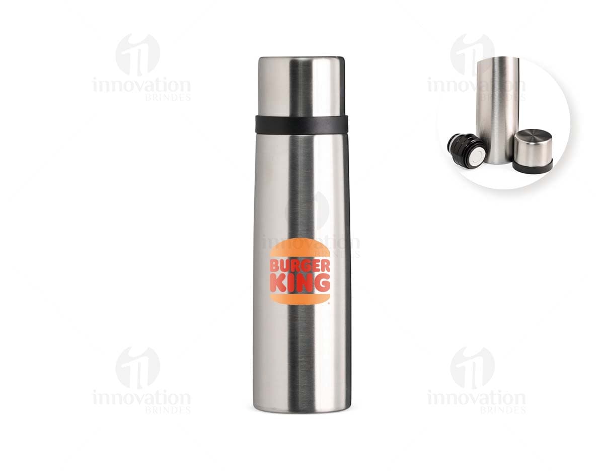 Garrafa térmica de 500ml em inox, com design elegante e tampa de metal, refletindo a luz. A garrafa é vazia e possui uma etiqueta amarela no corpo, garantindo frescor e praticidade para manter bebidas quentes ou frias. Ideal para uso em casa, no trabalho ou em viagens, proporcionando elegância e funcionalidade.