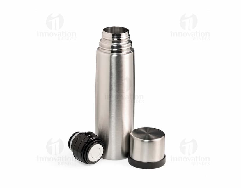 Garrafa térmica de 500ml em inox, com design elegante e tampa de metal, refletindo a luz. A garrafa é vazia e possui uma etiqueta amarela no corpo, garantindo frescor e praticidade para manter bebidas quentes ou frias. Ideal para uso em casa, no trabalho ou em viagens, proporcionando elegância e funcionalidade.