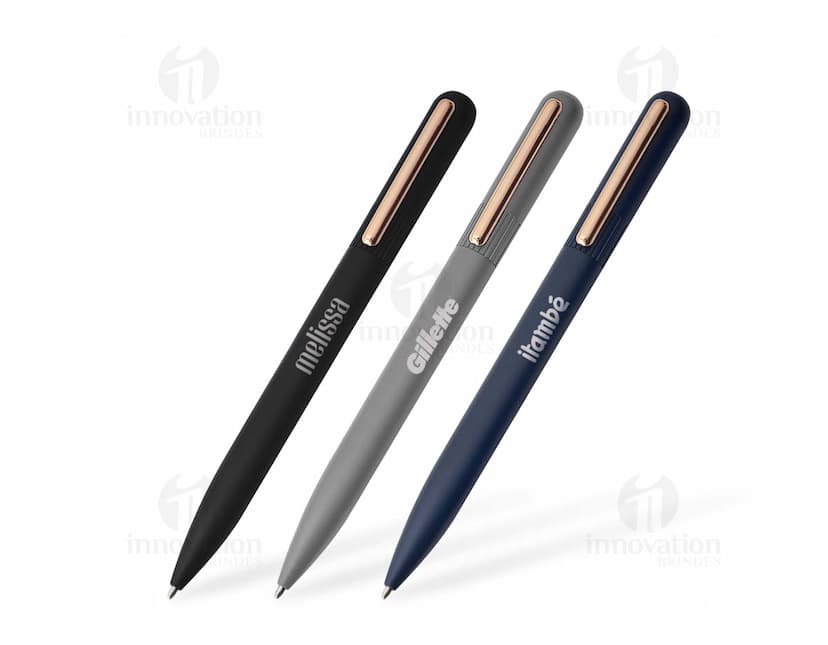 Caneta metálica prateada com detalhes em metal dourado e tinta azul.