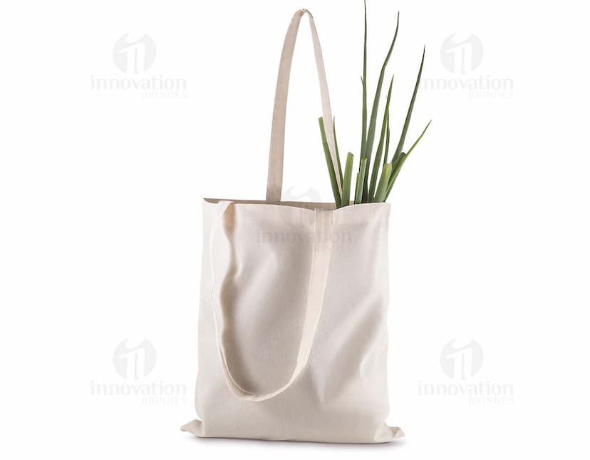 Sacola em algodão marrom com alça de couro, fecho de zíper e detalhes em metal. Produto moderno e elegante, ideal para compras e presentes. Elegância e segurança em um único acessório.
