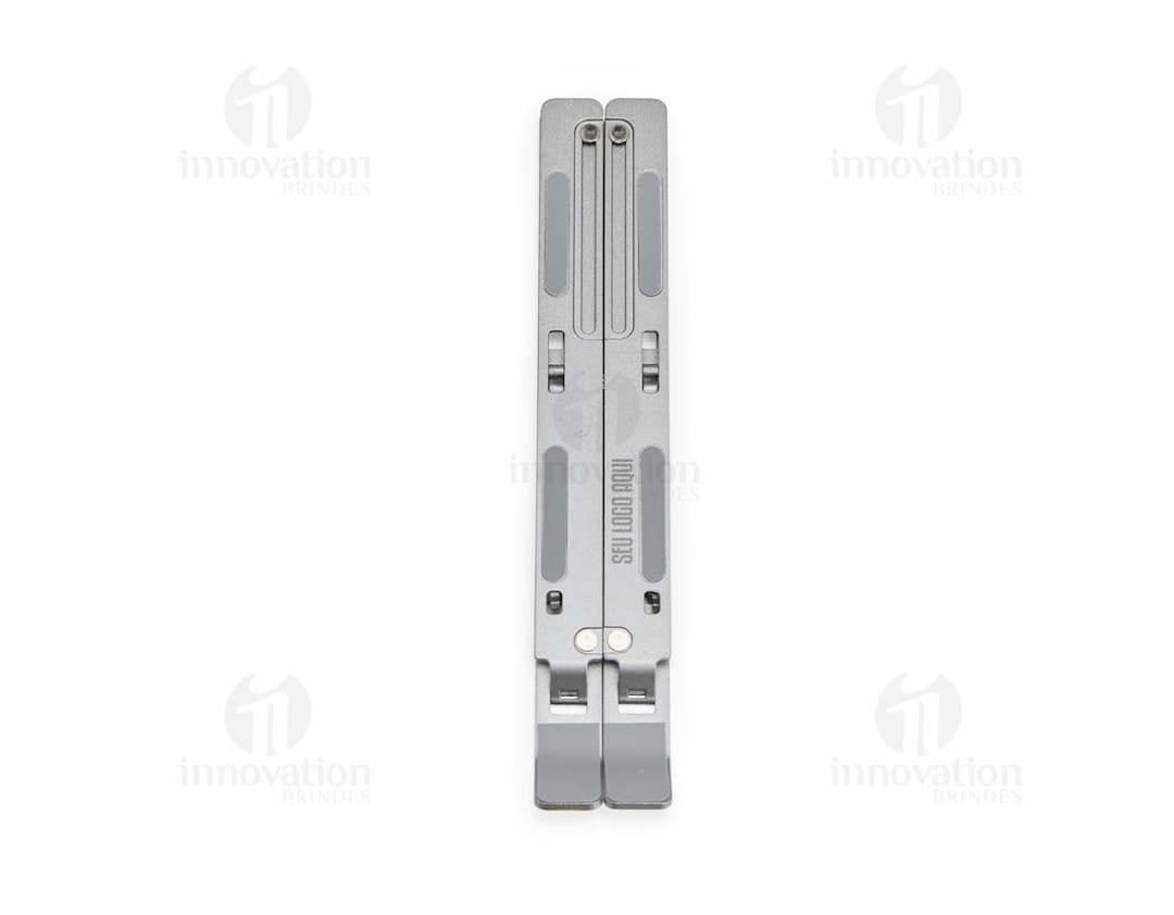 Suporte retrátil para notebook feito de metal e aço, sendo uma ferramenta tecnológica e moderna para facilitar o uso do dispositivo.