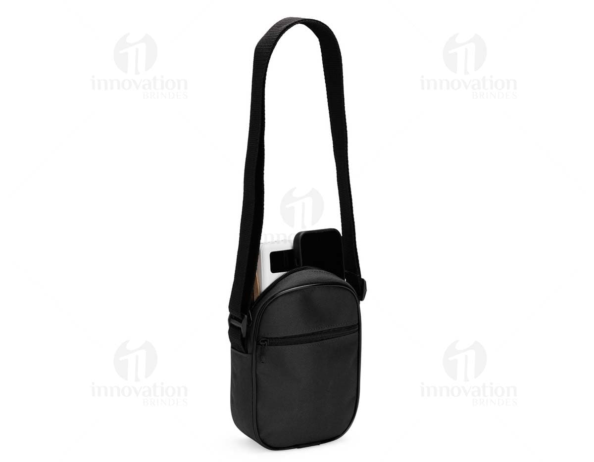 Bolsa de ombro de poliéster preta com alça de couro, fecho metálico, equipada com bolso interno e design moderno. Ideal para viagens e uso diário.