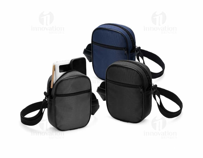 Bolsa de ombro de poliéster preta com alça de couro, fecho metálico, equipada com bolso interno e design moderno. Ideal para viagens e uso diário.