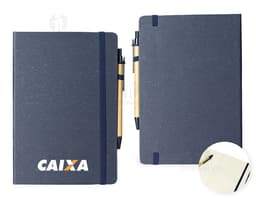 Rice fiber notebook with pen on a white background. The notebook is light brown with black details on the cover. The pen is