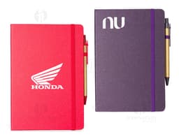 Rice fiber notebook with pen on a white background. The notebook is light brown with black details on the cover. The pen is