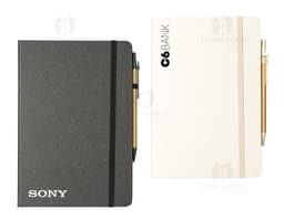 Rice fiber notebook with pen on a white background. The notebook is light brown with black details on the cover. The pen is