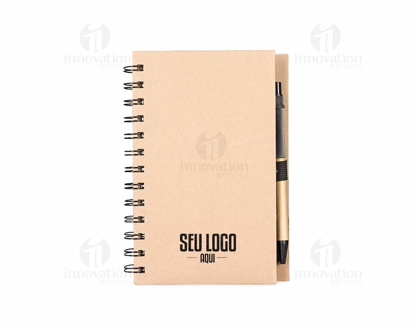 Caderno Ecológico com capa de papel kraft marrom, fecho de elástico e detalhe de folha verde. Páginas internas em papel reciclado.