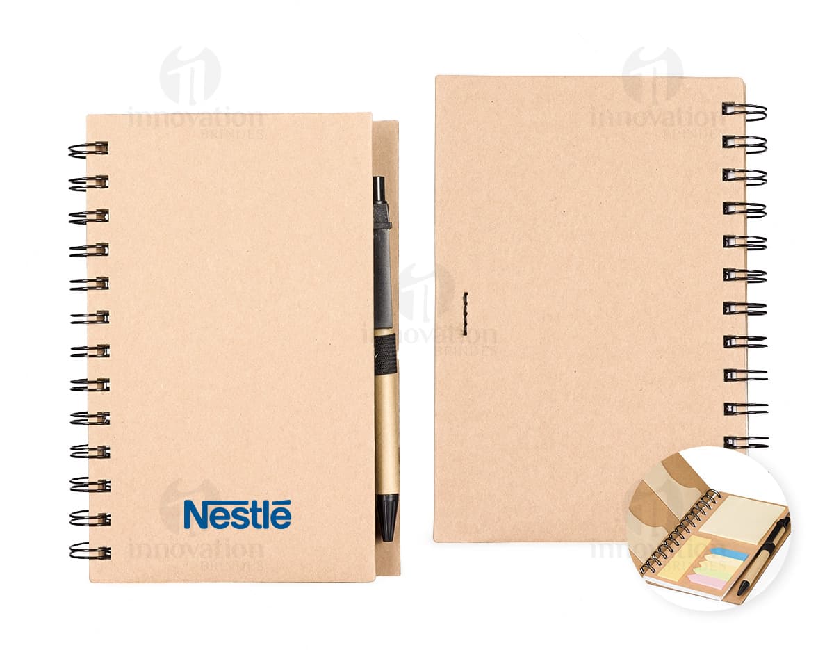 Caderno Ecológico com capa de papel kraft marrom, fecho de elástico e detalhe de folha verde. Páginas internas em papel reciclado.