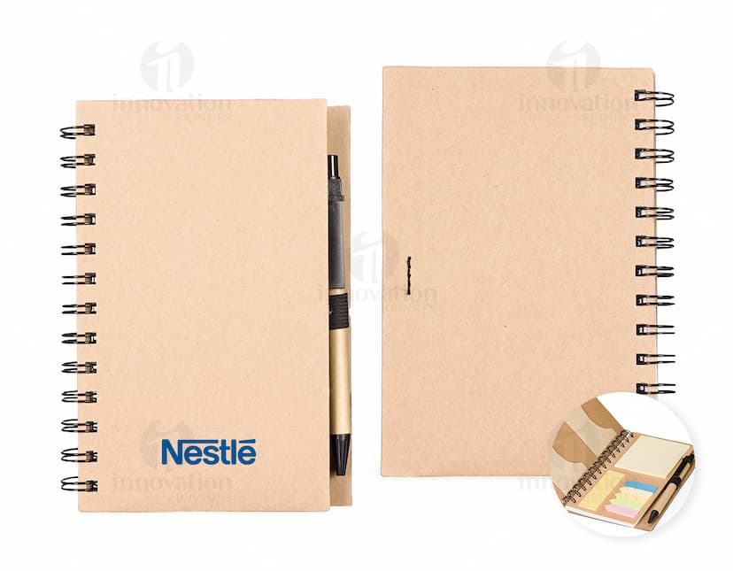 Caderno Ecológico com capa de papel kraft marrom, fecho de elástico e detalhe de folha verde. Páginas internas em papel reciclado.