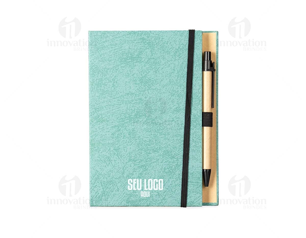 Bloco de anotações em papel reciclado com capa marrom e elástico azul, sobre uma mesa de madeira.