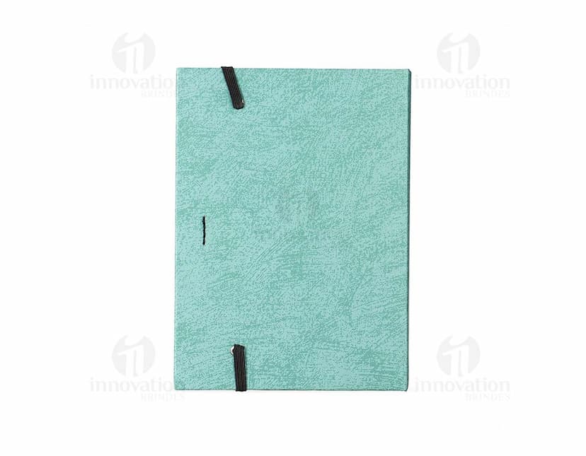 Bloco de anotações em papel reciclado com capa marrom e elástico azul, sobre uma mesa de madeira.