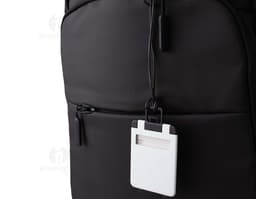 Brown leather luggage identifier tag with gold metal details and a strap for attaching to luggage.