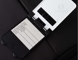 Brown leather luggage identifier tag with gold metal details and a strap for attaching to luggage.