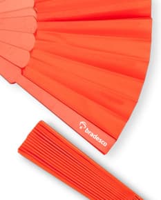 Leque de plástico colorido, com design moderno e brilhante. O leque possui formas geométricas em tons de amarelo, laranja, violeta, rosa e azul, lembrando um arco-íris. É um objeto decorativo e criativo, perfeito para escritórios, bibliotecas ou salas de estudo.