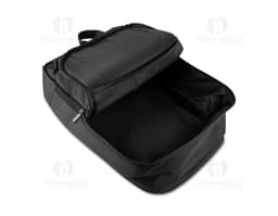 Homem de terno preto e pasta executiva, segurando uma mochila preta nas costas, em um ambiente corporativo.