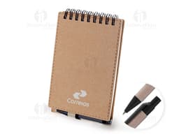 Mini caderno de anotações em papel em branco, com capa marrom de cartão. Acompanha uma caneta e está em cima de um notebook