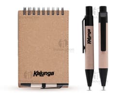 Mini caderno de anotações em papel em branco, com capa marrom de cartão. Acompanha uma caneta e está em cima de um notebook