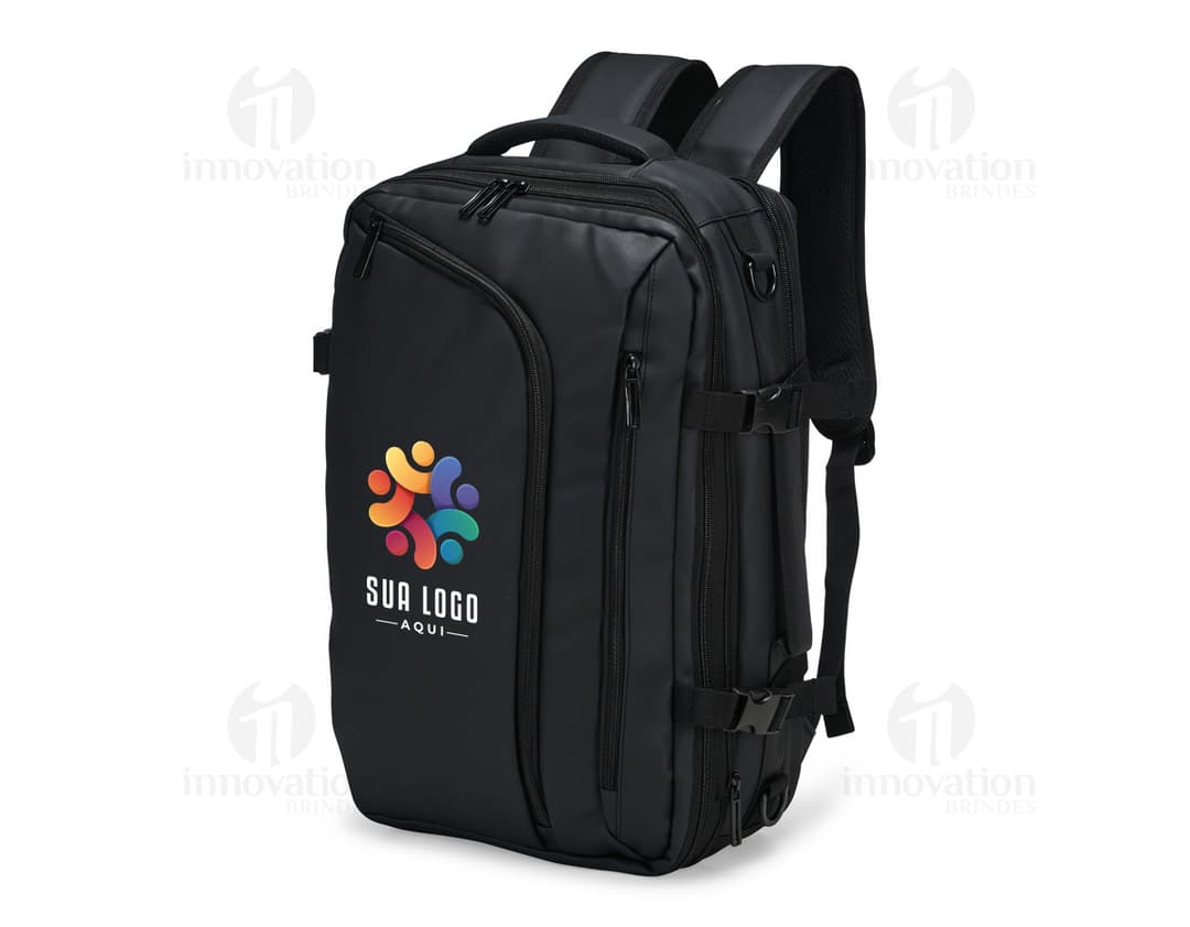 A smiling, well-dressed businessman holding a black leather backpack. He is standing in a studio and looks happy and