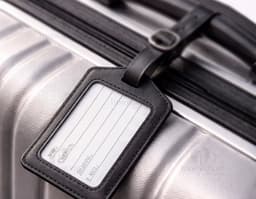 Black luggage identifier made of leather, with a closure and empty interior to insert information. With a compact and durable